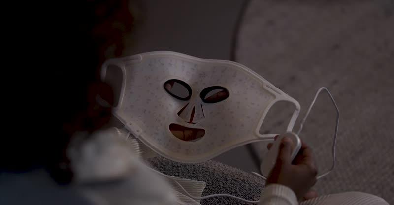 Video of woman putting on the Silk'n LED Face Mask 100, choosing her light technology treatment