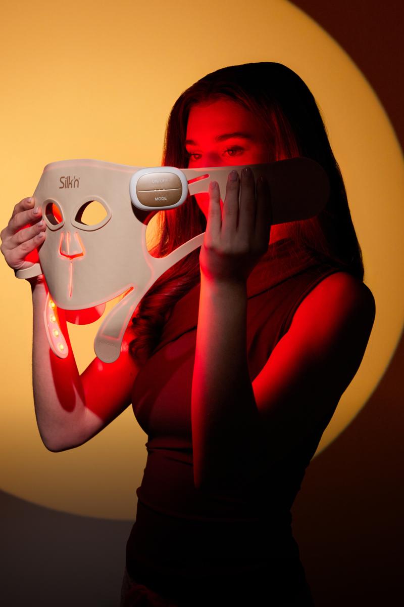 Mujer con m&aacute;scara LED profesional con terapia de luz roja.