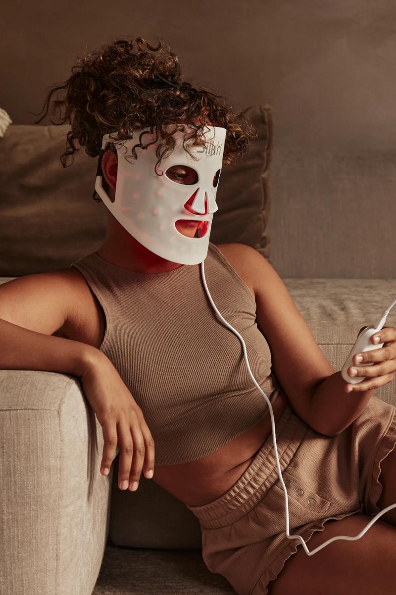 Woman using one of the 4 LED light therapy colors (blue light) treating various skin concerns such as acne and blemishes