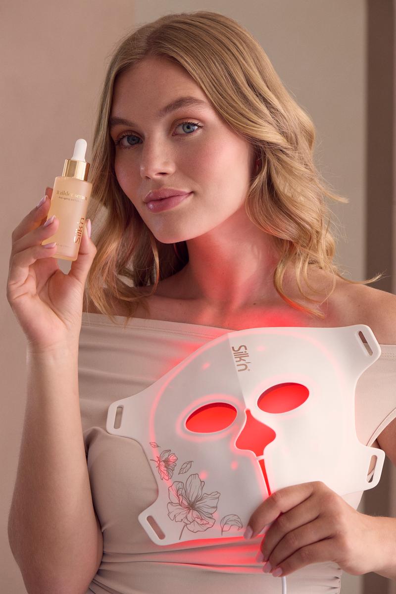 Femme tenant le s&eacute;rum Builder Serum ainsi que son masque LED pour le visage