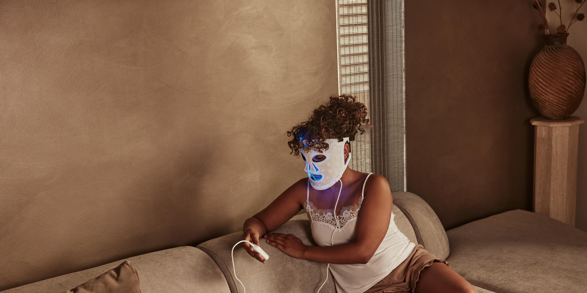 Benefits of LED Face Mask: woman using a LED face mask - blue light therapy