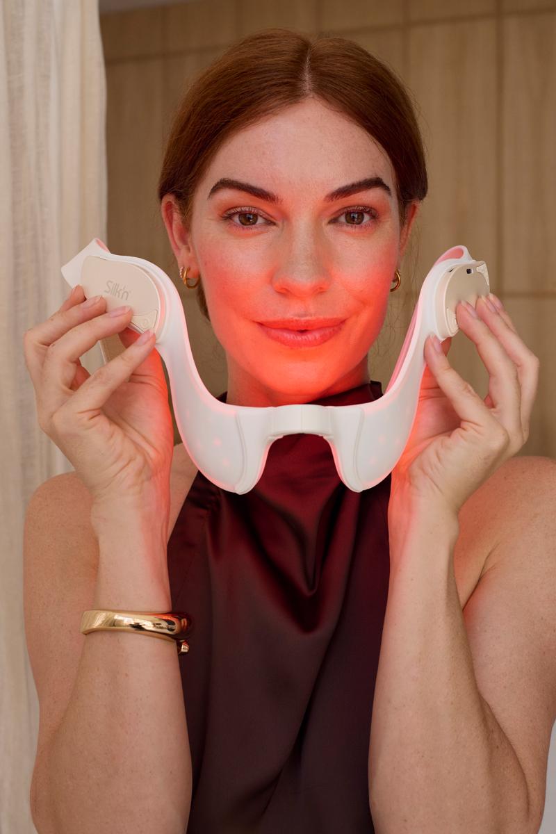 Woman putting on the red light device Silk'n LED TriLyft