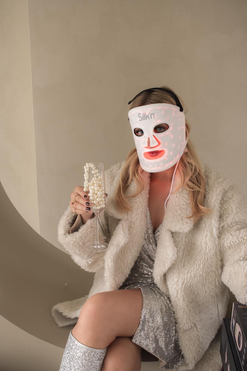 Woman wearing the Silk'n LED Face Mask 100 in festive season setting