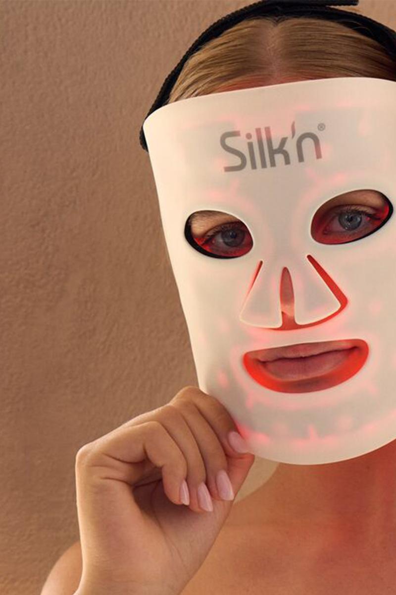 Woman wearing the LED Face Mask 100 from Silk'n using red light therapy for skin rejuvenation