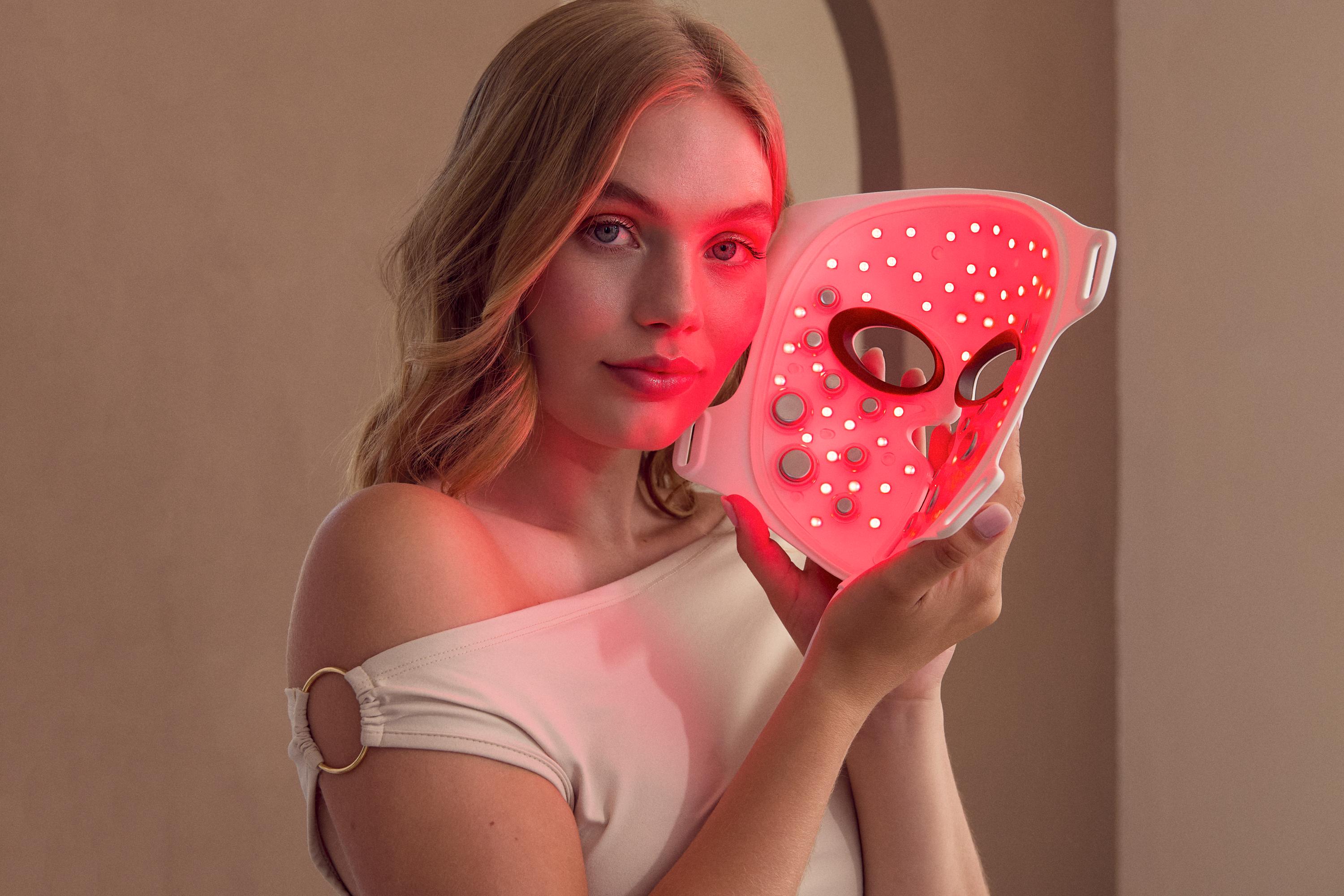 Une femme qui essaie le masque LED et EMS de Silk'n