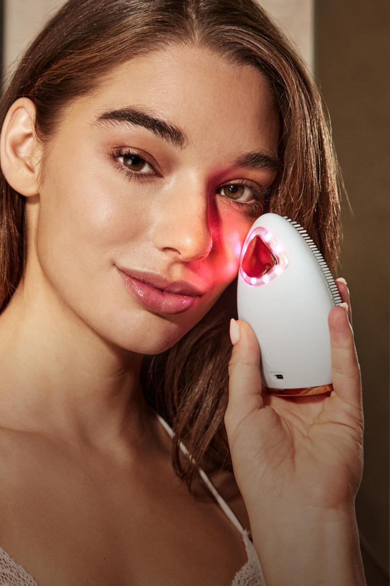 Belle femme avec le Bright Lux appareil des soins de visage