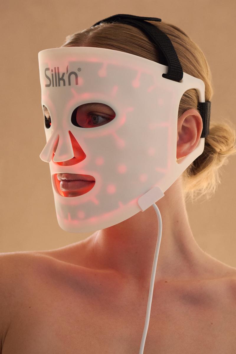 Woman using the LED Face Mask 100 of Silk'n with the goal to improve her skin and glow thanks to LED technology
