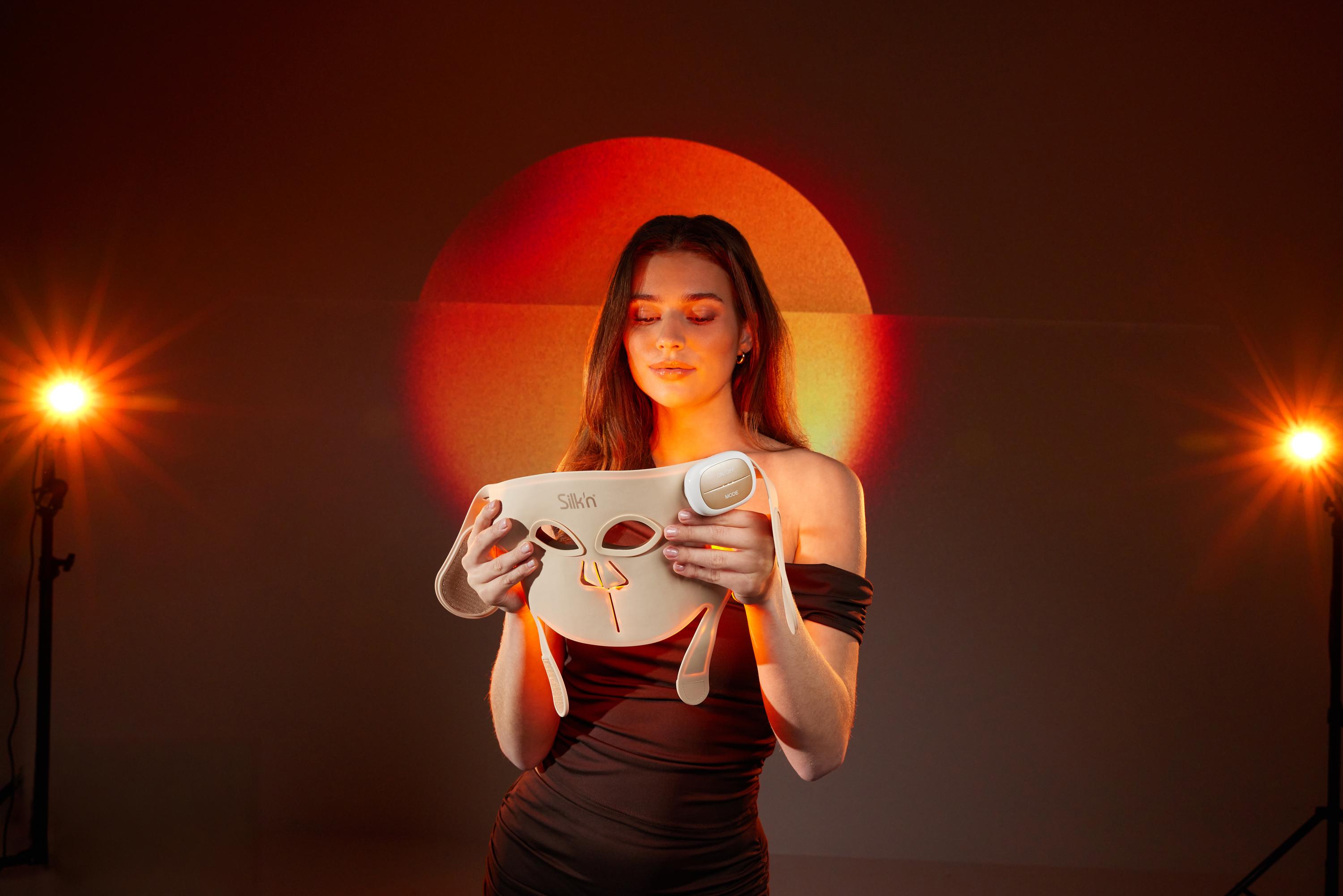 Woman watching her LED Face Mask Pro with red light