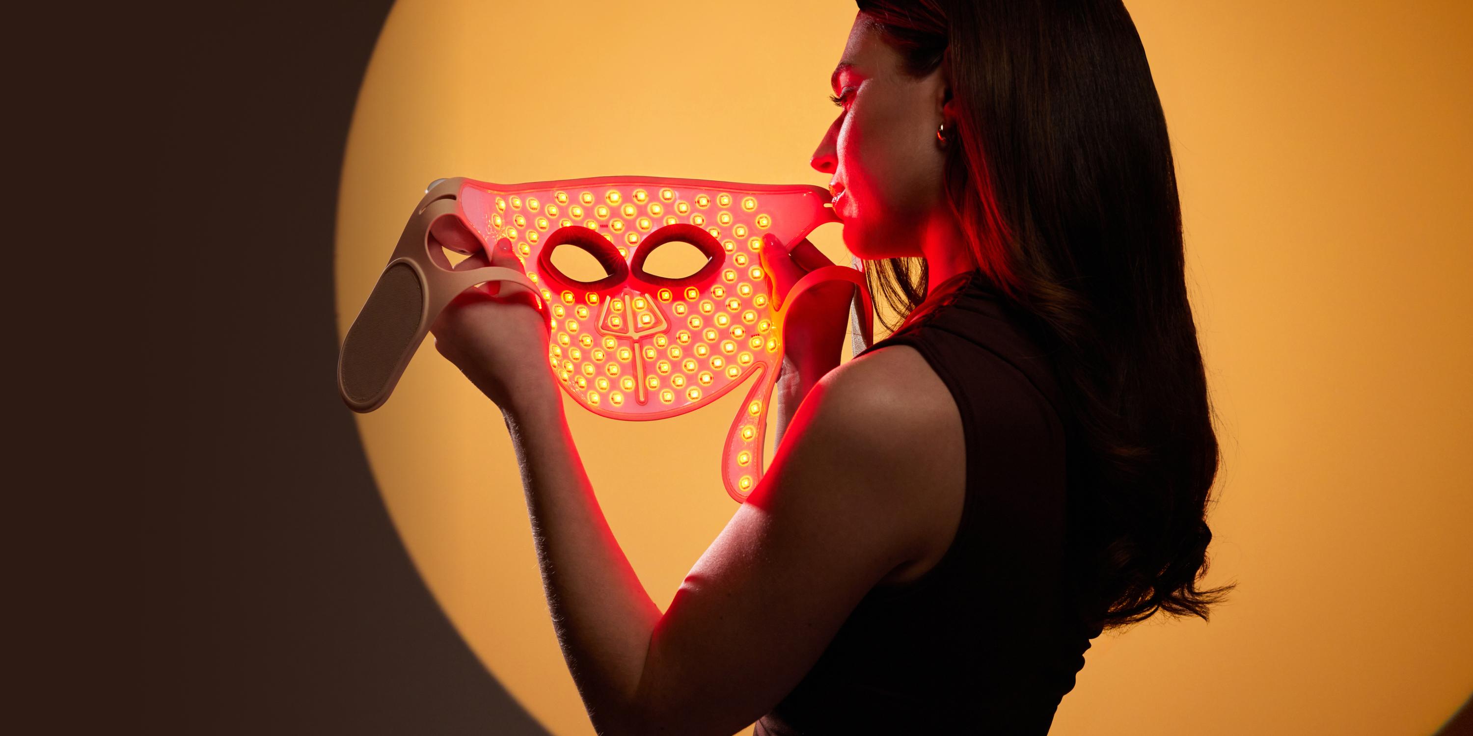 Mujer con m&aacute;scara LED profesional con terapia de luz roja.