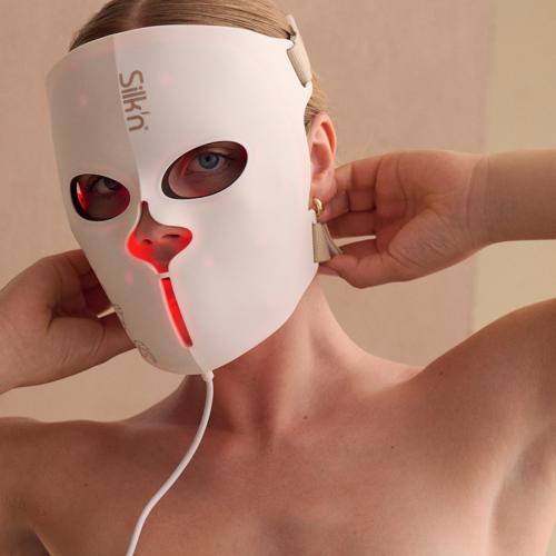 Woman wearing the LED EMS Face Mask that includes muscle stimulation